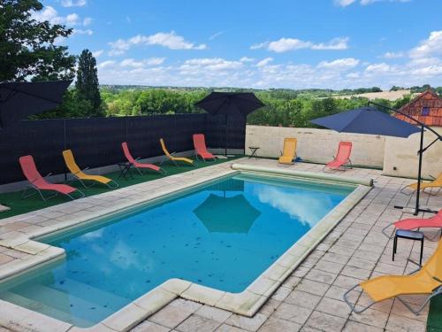 une piscine avec chaises et parasols sur un patio dans l'établissement Gîte rénové avec piscine partagée à Saint-Méard-de-Drône - FR-1-616-468, à Villetoureix