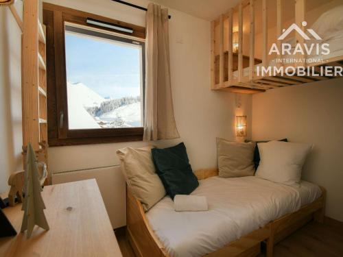 un petit lit dans une chambre avec une fenêtre dans l'établissement Appartement moderne 6 pers., confortable avec balcon - Le Grand-Bornand - FR-1-391-210, au Grand-Bornand