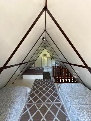 a attic room with two beds and a window at Chalé em Ubatuba para 12 pessoas com Wi-Fi in Ubatuba