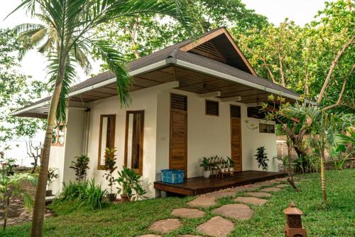 a small white house with a pathway in front of it at Murex Dive Resort in Manado