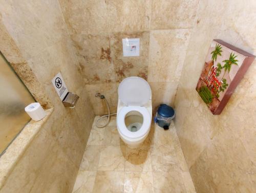 a bathroom with a toilet in a tiled room at Private Pool Villas Kuta Bali in Kuta