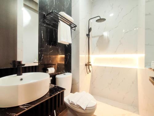 a bathroom with a sink and a toilet and a shower at Aka Exclusive in Seturan