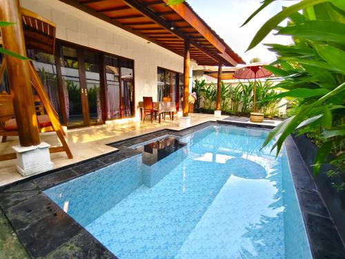 a swimming pool in front of a house at Private Pool Villas Kuta Bali in Kuta
