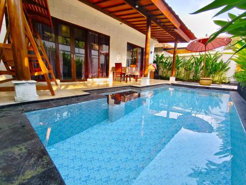 a swimming pool in front of a house at Private Pool Villas Kuta Bali in Kuta