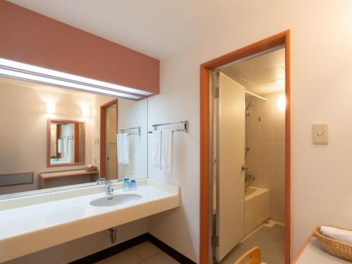 a bathroom with a sink and a shower at Hotel Atollemerald Miyakojima in Miyako Island