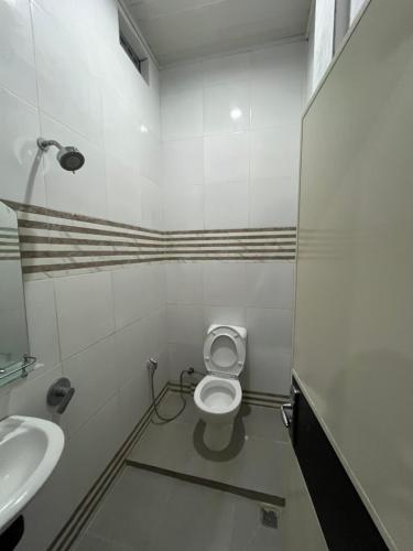 ein Badezimmer mit Toilette und Waschbecken in der Unterkunft Sapo Rumbia Homestay in Berastagi