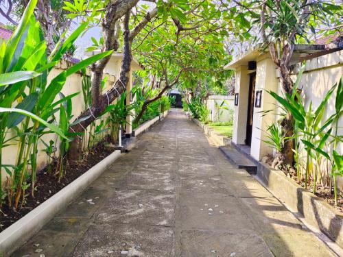 an alley way in a garden with trees at Private Pool Villas Kuta Bali in Kuta
