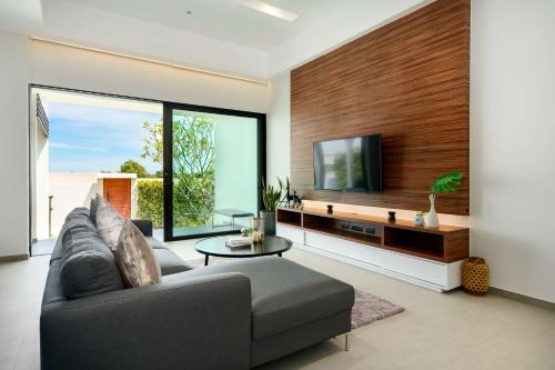 a living room with a couch and a tv at Sivana HideAway Villas in Khao Tao