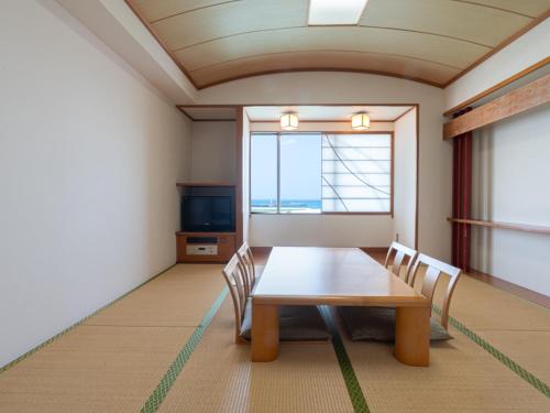 a room with a table and chairs and a window at Hotel Atollemerald Miyakojima in Miyako Island