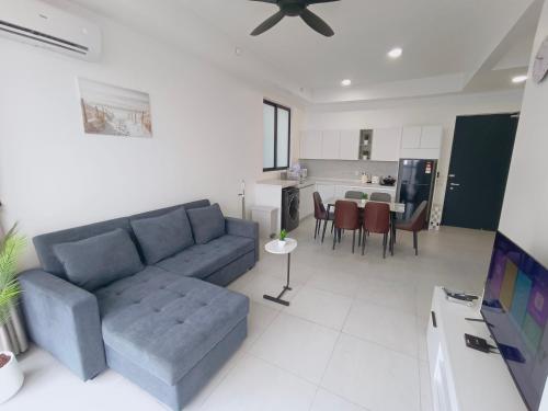 Infinity Pool, Urban Suites, Georgetown, 2 Car Parks by Star Home في جورج تاون: غرفة معيشة مع أريكة زرقاء ومطبخ