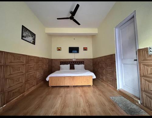 a bedroom with a bed and a ceiling fan at malangbybumblebee in Kasol
