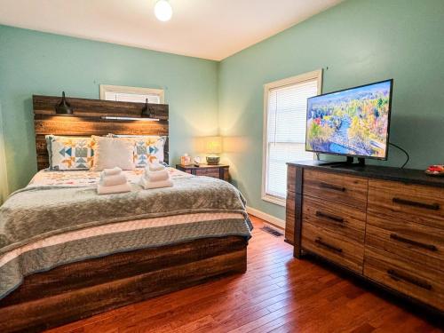 a bedroom with a large bed and a flat screen tv at NEW - Mins to DHMC/ Hanover- House - Pet Friendly in Lebanon