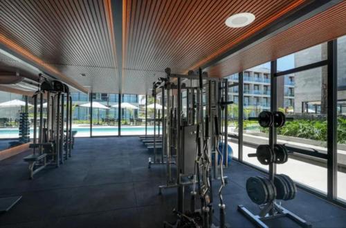 une salle de sport avec des équipements cardio dans un bâtiment dans l'établissement Apartamento de Luxo no Resort GAV, Muro Alto, Porto de Galinhas, à Ipojuca