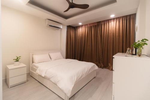 a bedroom with a white bed and a ceiling fan at Sunrise Stay 203 Comfy Modern Room in Hulhumale by the Beach in Hulhumale