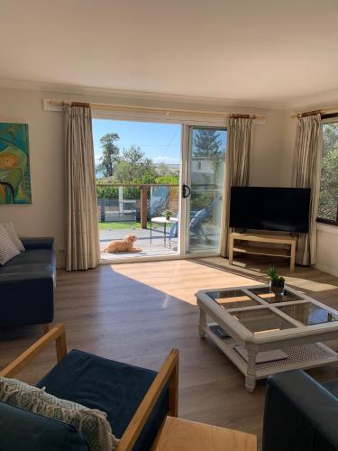 a living room with a couch and a table at By The Sea, Culburra Beach in Culburra Beach
