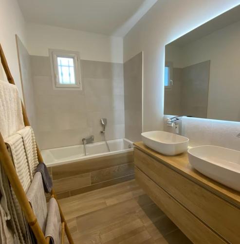 une salle de bain avec deux lavabos, une baignoire et un miroir dans l'établissement Villa avec vue sur le pilon du roi, à Aix-en-Provence