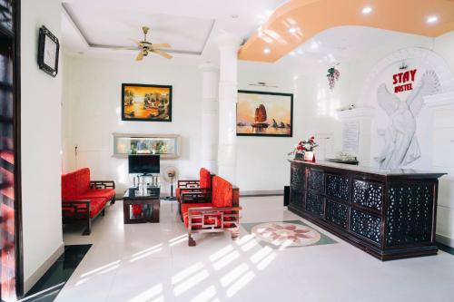 a living room with red chairs and a table at Stay Hostel in Thôn Dương Xuân Hạ