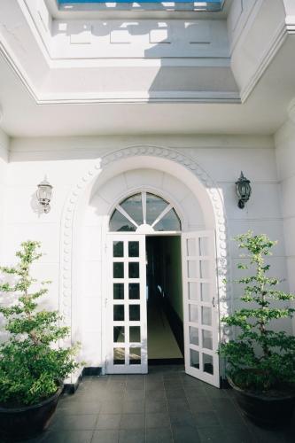 an entrance to a white building with a door at Stay Hostel in Thôn Dương Xuân Hạ