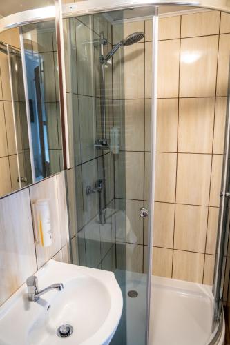 a bathroom with a sink and a glass shower at Pokoje Gościnne Na Szlaku in Krościenko