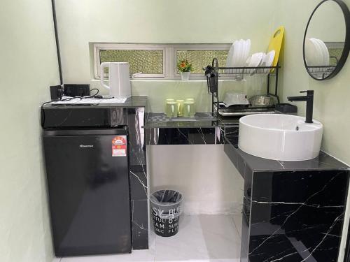 a bathroom with a counter with a sink and a mirror at AR HOMESTAY & ROOMESTAY in Merlimau