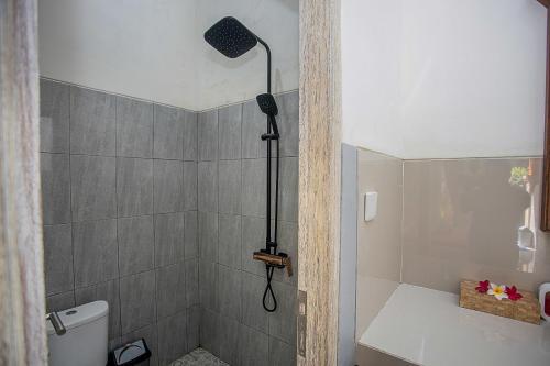 a bathroom with a shower with a shower head at Samana Homestay in Nusa Lembongan