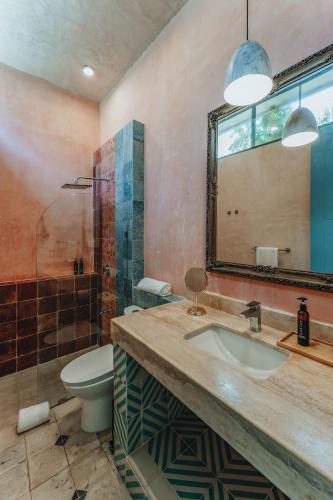a bathroom with a sink and a toilet and a mirror at A-Wotoch Centro de Mérida in Mérida