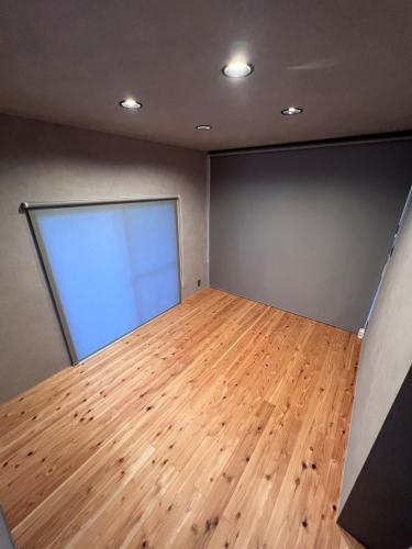 an empty room with a large window and wooden floor at Nasu Sauna Stay in Nasu