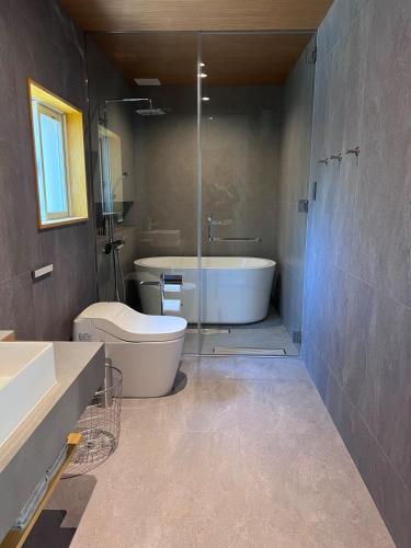 a bathroom with a tub and a toilet and a sink at Nasu Sauna Stay in Nasu