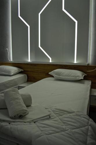 a bedroom with two beds with lights on the wall at Apartments Good Night in Niš