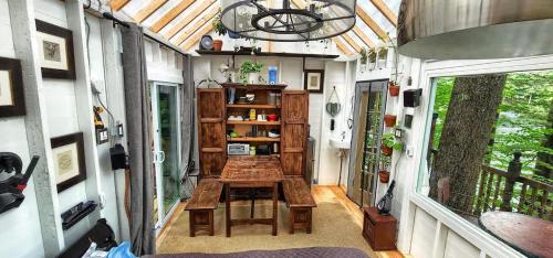 a tiny house with a wooden table on a porch at Stabbin Cabin #2 on Grant Island - Hot Tub, Boat, Pet Friendly in Glenfield