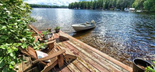 a boat sitting on a dock on a lake at Stabbin Cabin #2 on Grant Island - Hot Tub, Boat, Pet Friendly in Glenfield