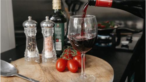 a bottle of wine being poured into a wine glass at Raintree Farmstay by Tiny Away in Sarsfield