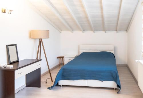een witte slaapkamer met een bed en een bureau bij Villa Moon - Tranquil 3BR Villa with Private Pool in Koycegiz