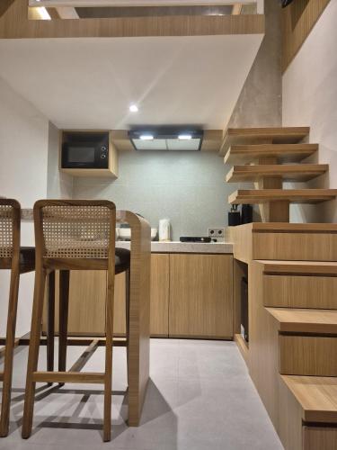 a kitchen with a staircase and a table and chairs at Keenan Living Luxe Seturan in Seturan