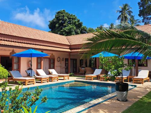 a resort with a swimming pool with chairs and umbrellas at Laura's Guest House-adult only- in Lamai