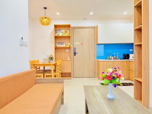 a kitchen and dining room with a vase of flowers on a table at X O HOMESTAY Nera Apartment Huế in Hue