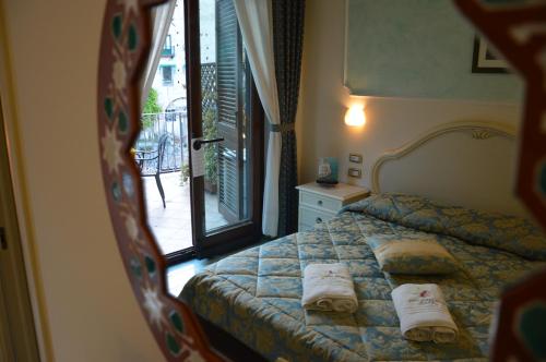 a bedroom with a bed with two towels on it at Hotel Santa Lucia in Minori