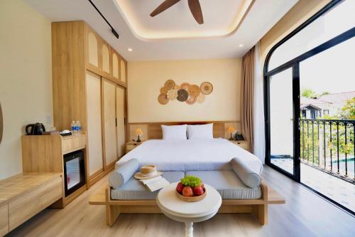 a bedroom with a bed and a table with fruit on it at Naraco Homestay Hoi An in Cam Thanh