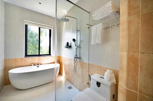 a bathroom with a sink and a glass shower at Naraco Homestay Hoi An in Cam Thanh