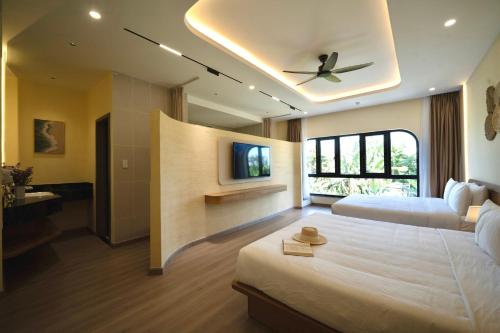 a bedroom with two beds and a ceiling fan at Naraco Homestay Hoi An in Cam Thanh