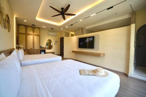 a bedroom with two beds and a ceiling fan at Naraco Homestay Hoi An in Cam Thanh