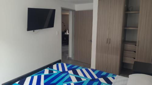 a living room with a television and a bed at Hotel La Posada in Belén de Umbría