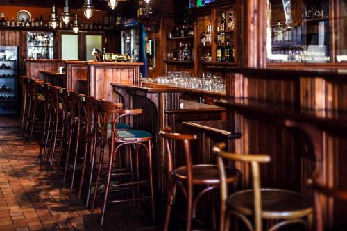 a bar with wooden bar stools in a room at Interhotel Zlín in Zlín