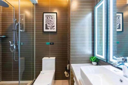 a bathroom with a shower and a toilet and a sink at Xana Hotelle Binzhou Yangxin in Binzhou