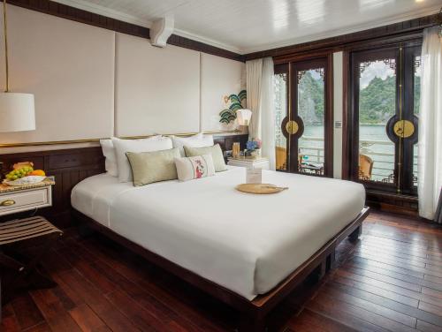 un grande letto bianco in una stanza con una finestra di Bhaya Luxury Halong Cruise - Manage by LuxCruises a Ha Long