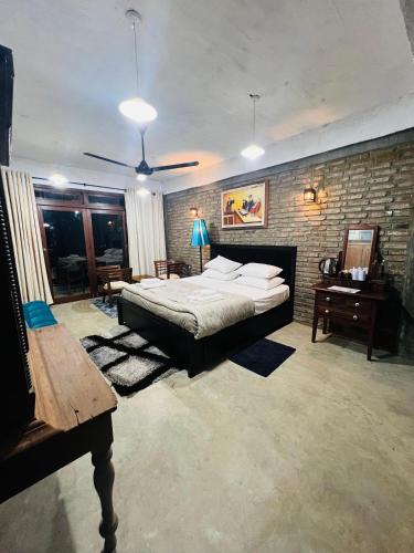 a bedroom with a bed and a brick wall at Aayu Hanthana Boutique Hotel in Kandy