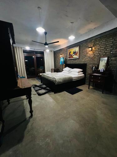 a bedroom with a bed and a brick wall at Aayu Hanthana Boutique Hotel in Kandy