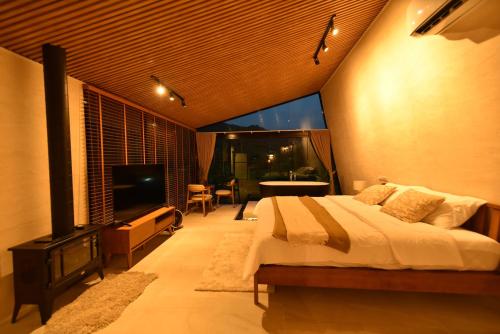 a bedroom with a bed and a flat screen tv at Take Time Nature Resort in Ban Tha Sai