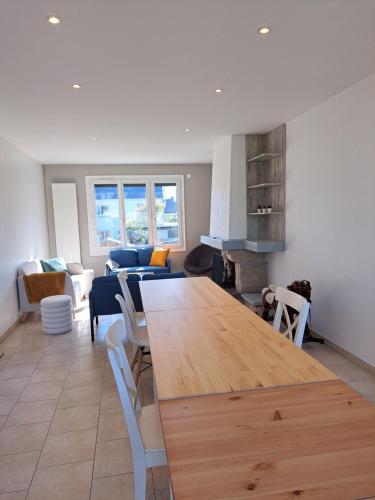Il comprend une cuisine et un salon avec une grande table en bois. dans l'établissement Villa ouvrière 5 chambres, à Trignac