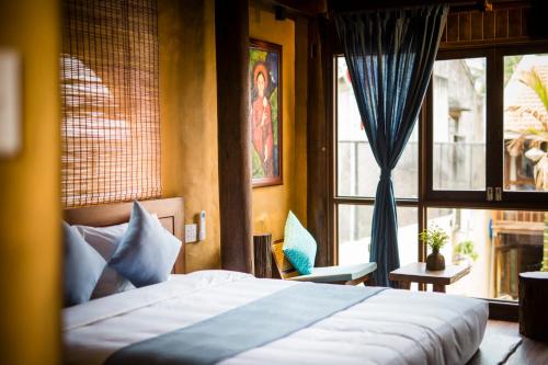 a bedroom with a bed and a large window at Hoi An Hidden Boat in Hoi An
